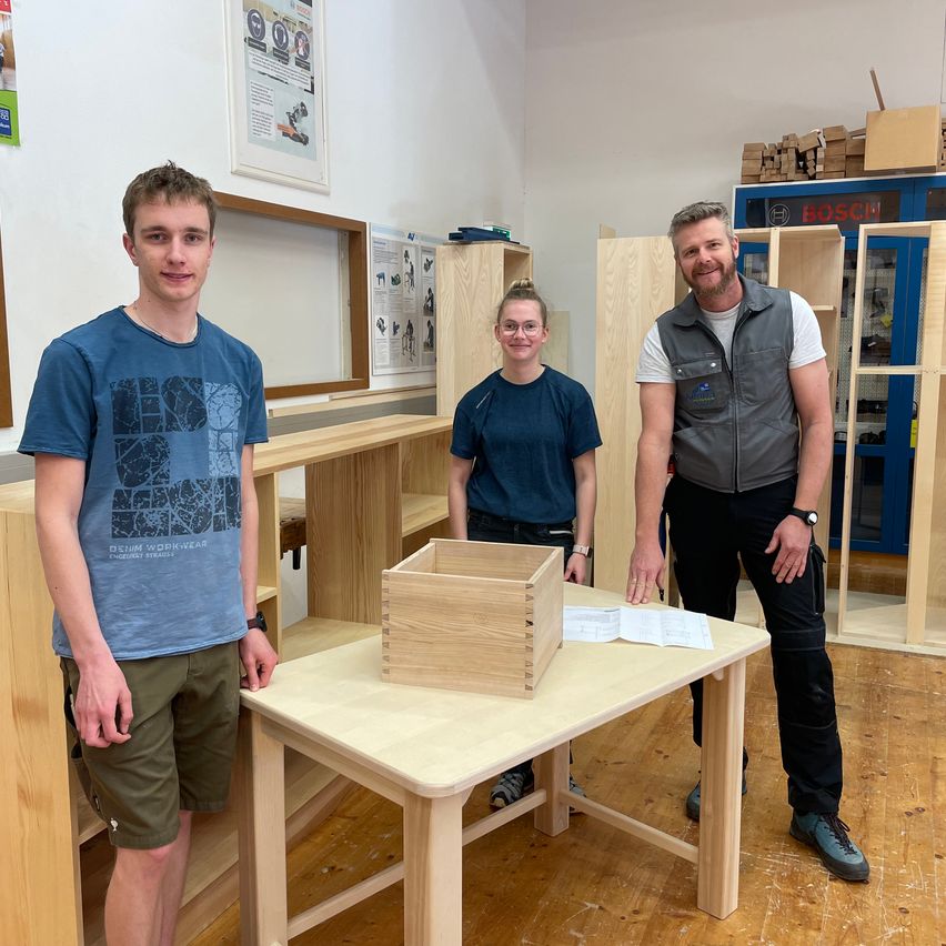 Bild enthält, Plywood, Wood, Hardwood, Wristwatch, Desk, Person, Adult, Male, Man, Pants