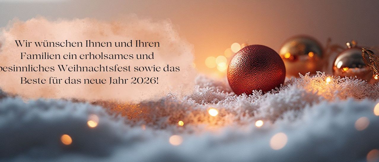 Eine rote Weihnachtskugel liegt auf einer verschneiten Oberfläche mit einer festlichen Botschaft, goldene Lichter leuchten im Hintergrund.