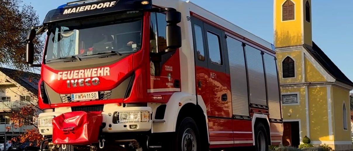 Ein roter Iveco-Feuerwehrwagen mit dem Wort 'Feuerwehr' auf der Seite und dem Kennzeichen 'FW 411 SO'. Das Fahrzeug ist auf der Straße geparkt.