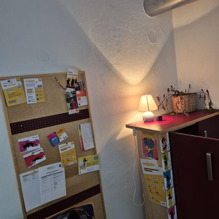 Bild enthält, Indoors, Interior Design, Person, Desk, Furniture, Table, Lamp, Shelf