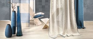 Ein Zimmer mit Holzboden, blau-weiß gestreifter Wand, zwei blauen Vasen, einem Holzstuhl mit Kissen und einem weißen Vorhang mit Muster.