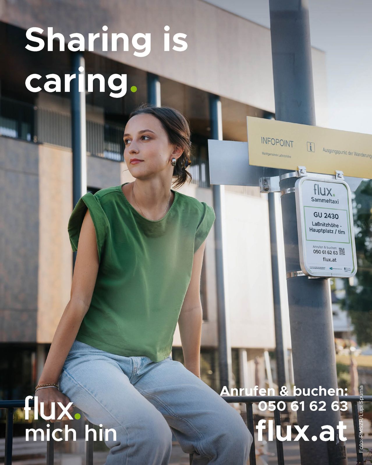 A woman in a green shirt poses outside a building with a taxi sign nearby. The sign reads 'Infopoint'. Another sign nearby has 'flux' and contact information.