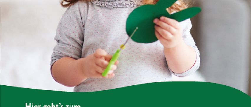 Ein junges Mädchen hält eine grüne Papier-Schmetterling in den Händen. Der Text auf dem Bild lautet 'Hier geht es zum Kinderportal vom Land Steiermark.' Das Mädchen lächelt in die Kamera.