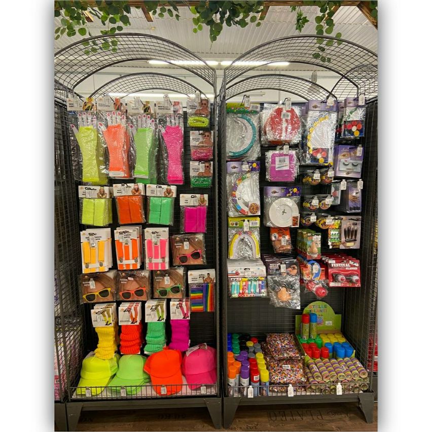 A display of party supplies and decorations, including neon accessories, hats, and colorful items.