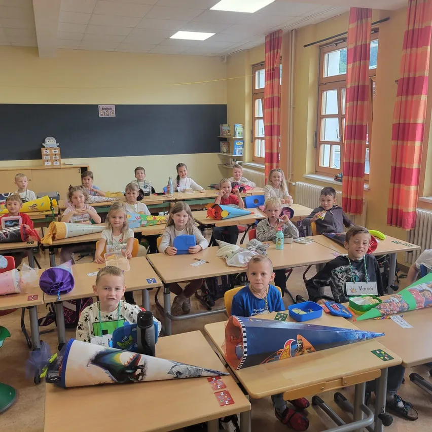 Ein Klassenzimmer voller Kinder, die an ihren Tischen sitzen, einige mit Kegeln auf ihren Tischen, die an Aktivitäten teilnehmen.