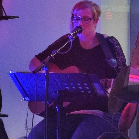 Bild enthält, Performer, Person, Solo Performance, Music, Musical Instrument, Musician, Microphone, Glasses, Singing, Face