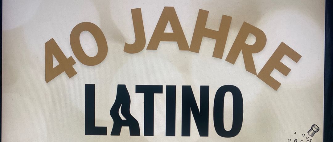 Werbeplakat für Latino Lounge Bar zum 40-jährigen Jubiläum. Veranstaltungsdatum ist der 28. November 2025. Altersbeschränkung ab 18 Jahren. Champagnerflasche, die mit Schaum spritzt.