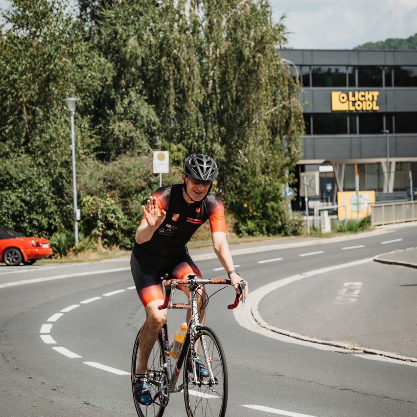 Bild enthält, Helmet, Bicycle, Cycling, Person, Vehicle, Machine, Wheel, Car, Road, Shorts