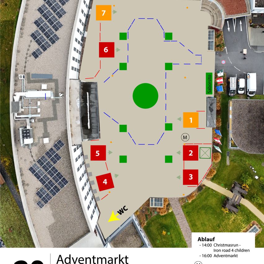 Luftaufnahme eines Marktbereichs mit nummerierten Zonen, Solarmodulen und einem grünen Kreis mit der Aufschrift 'WC'. Es gibt Gebäude, einen Parkplatz und eine Straße mit Fahrzeugen. Der Bereich ist von Gras umgeben.