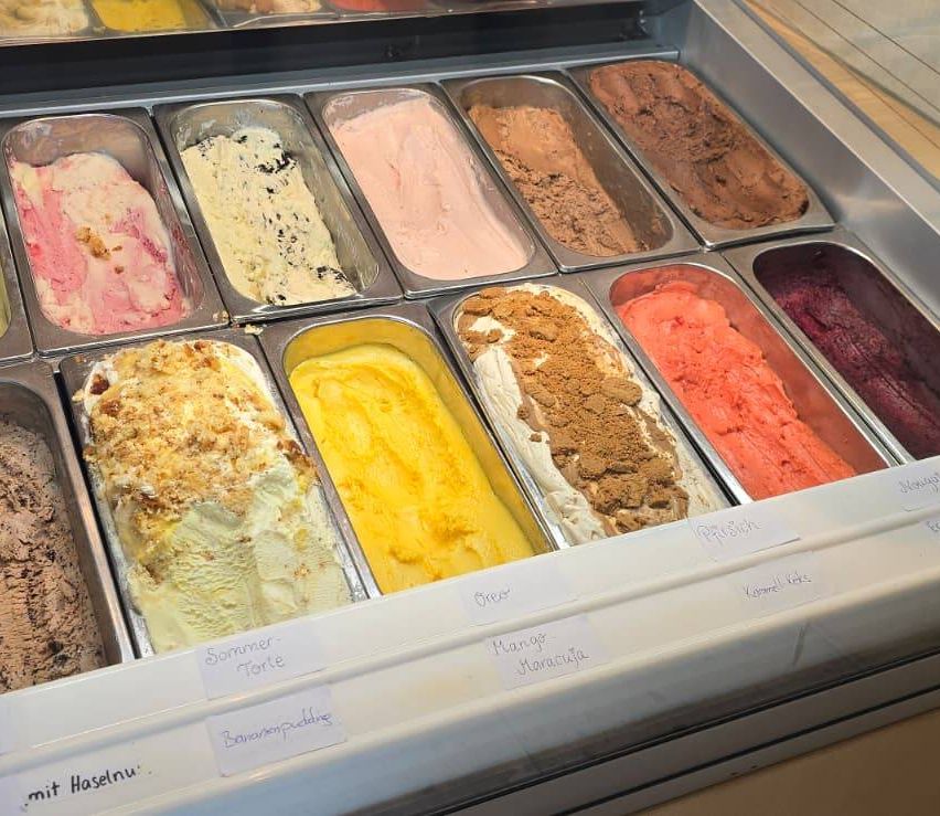 Eine Vitrine mit verschiedenen Eissorten, darunter Summer Torte, Banana Pudding, Mango Maracuja und andere.