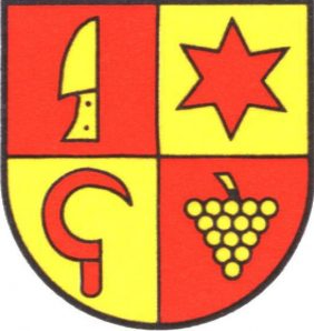 Das Wappen zeigt einen Schild, der in vier Teile geteilt ist, mit einem Messer, einer Sichel, einem roten Stern und Trauben.
