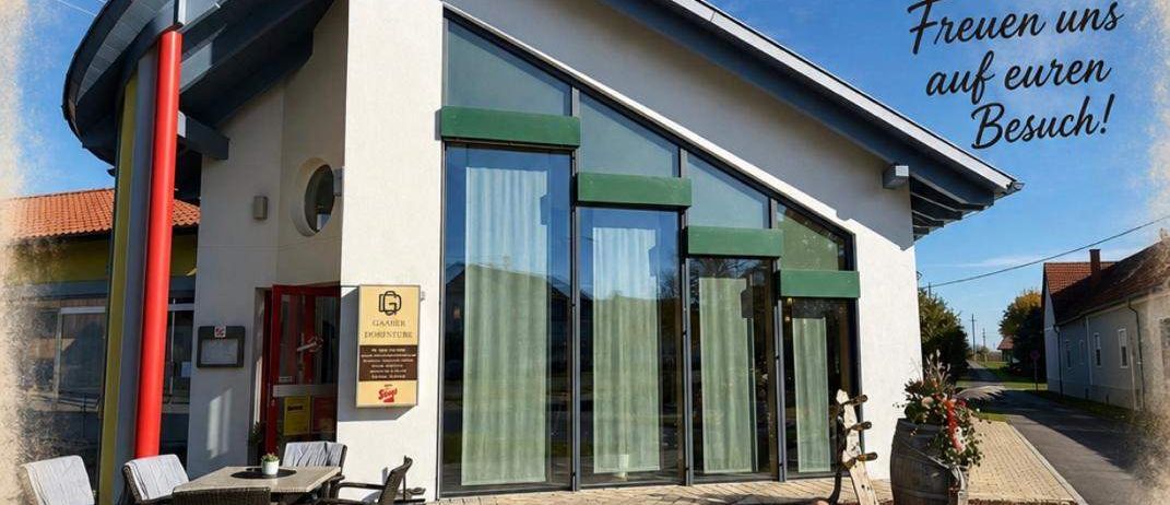 Ein Plakat für eine Veranstaltung am Samstag, den 25. Juli in einem Dorfgemeinschaftshaus. Es zeigt ein Haus mit Terrasse, Tisch, Stühlen und einer Schüssel mit Essen. Das Plakat enthält ein Herzsymbol und eine Einladung an Besucher.