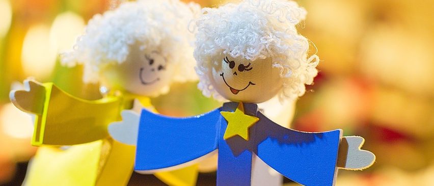 Zwei handgefertigte Engelschmuckstücke mit weißen Locken, einer trägt ein gelbes Kleid und der andere ein blaues Kleid mit einem gelben Stern.