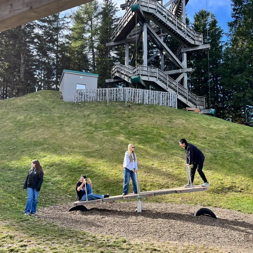 Eine Gruppe von Menschen spielt auf einer Wippe in einem Park.