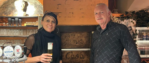 Ein Mann und eine Frau lächeln vor einer Wand mit den Worten Lama Casa in die Kamera.