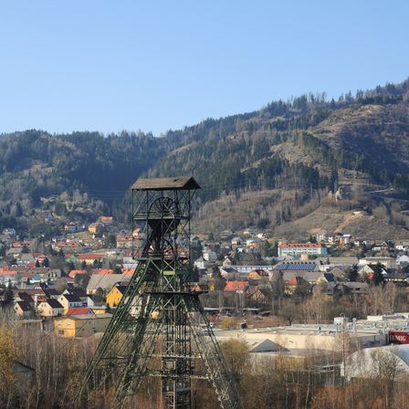 Eine Stadt mit vielen Häusern und einem hohen Metallturm in der Mitte unter einem klaren Himmel.