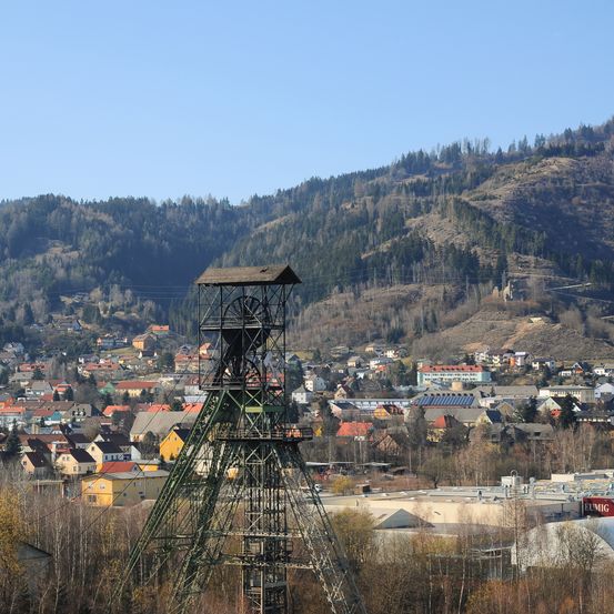 Eine Stadt mit vielen Häusern und einem hohen Metallturm in der Mitte unter einem klaren Himmel.