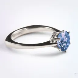 Ein Silberring mit einem großen blauen Saphir-Zentralstein in einem silbernen Rahmen. Der Schriftzug 'Revisto' ist auf dem Innenband eingraviert.