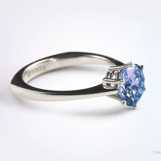 Ein Silberring mit einem großen blauen Saphir-Zentralstein in einem silbernen Rahmen. Der Schriftzug 'Revisto' ist auf dem Innenband eingraviert.