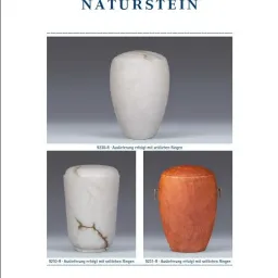 Eine weiße Keramikurne mit einem Riss und zwei kleinere Urnen, eine aus Marmor und eine aus Holz, alle mit sichtbaren Ringen.