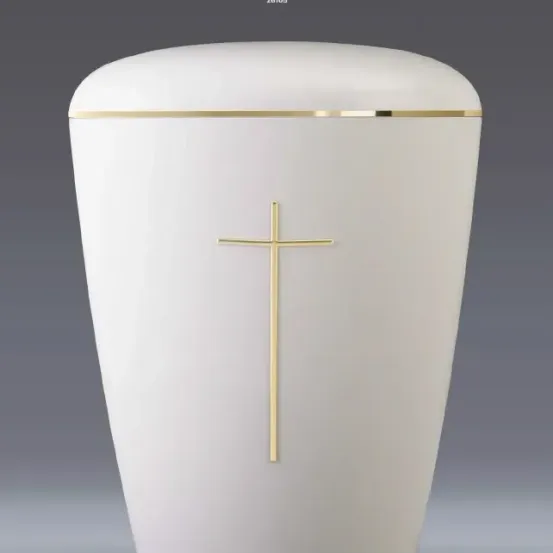 Eine weiße Urne mit einem goldenen Kreuz darauf. Die Urne ist zylindrisch und steht auf einem grauen Hintergrund.