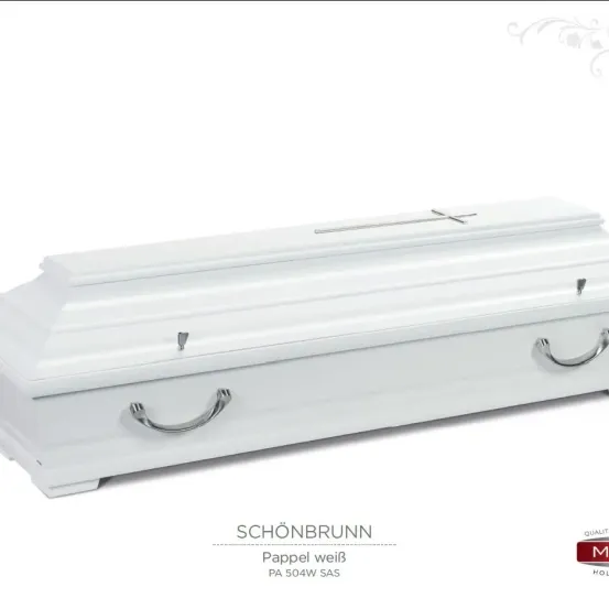 Ein weißer Sarg mit einem Kreuz auf der Oberseite und silbernen Griffen wird gezeigt. Der Markenname 'SCHÖNBRUNN' und 'Pappel weiß' sind darunter geschrieben. Der Sarg besteht aus Papier.