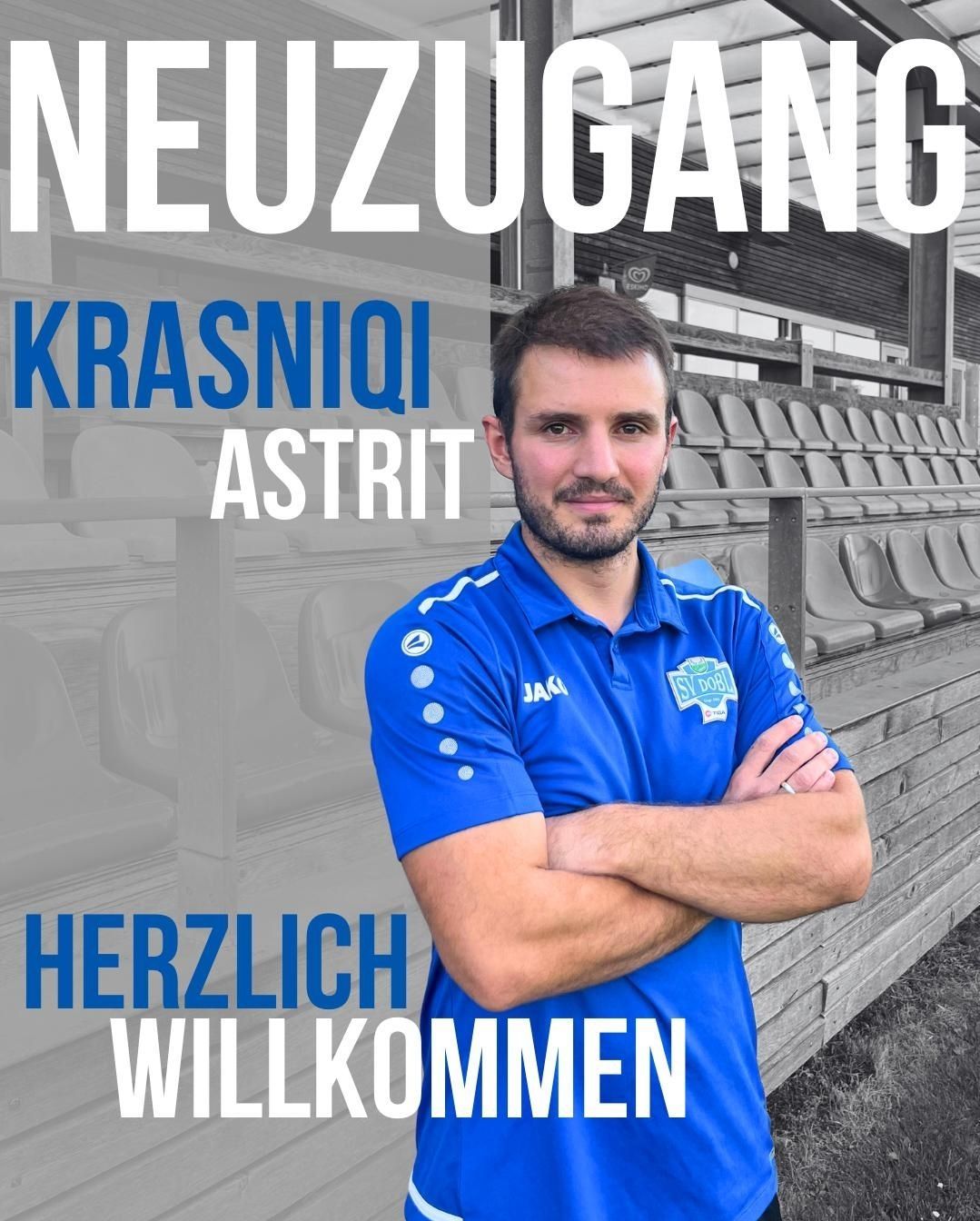 Ein Mann steht mit verschränkten Armen vor einem Stadion, trägt ein blaues Shirt mit einem Logo auf der linken Brust. Der Text 'Neuzugang Krasniqi Astrit' und 'Herzlich Willkommen' ist über und unter ihm angezeigt.