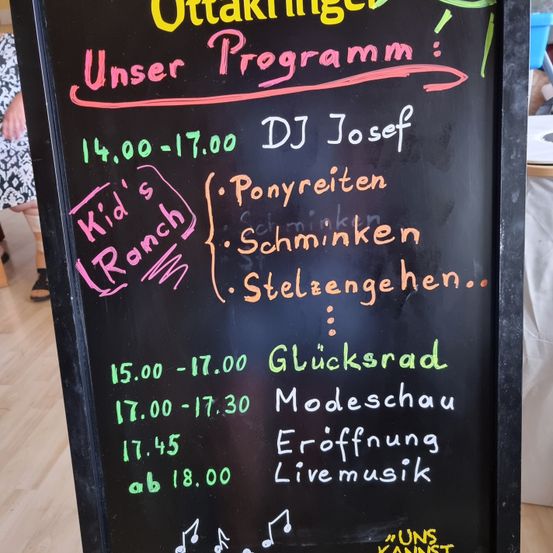 Eine Tafel mit einem Zeitplan für einen Tag. Es enthält Aktivitäten wie Ponyreiten, Ponyrennen, Ponyfahrten und eine Modenschau. Die Zeiten sind von 14:00 bis 18:00 Uhr angegeben.