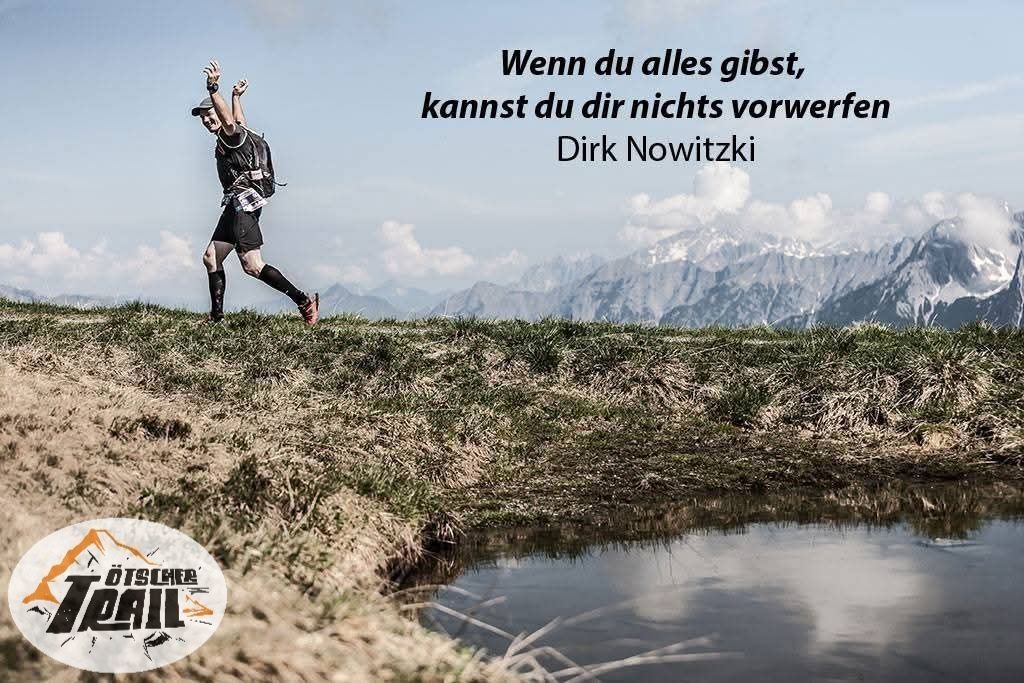 Ein Läufer auf einem grasigen Hang mit Bergen im Hintergrund. Der Spruch lautet: 'Wenn du alles hast, kannst du dir nichts vorwerfen' von Dirk Nowitzki.