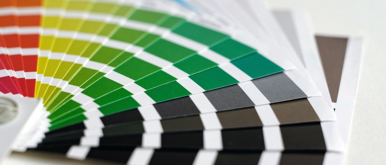 Nahaufnahme eines Farbkarten mit verschiedenen Grün-, Blau-, Grau- und Schwarztönen.