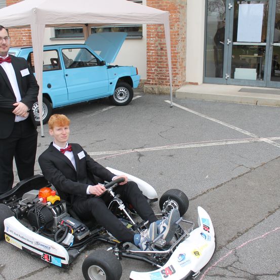 Bild enthält, Spoke, Person, Adult, Male, Man, Formal Wear, Suit, Kart, Wheel, Car