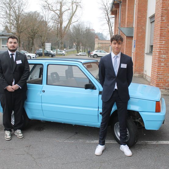 Bild enthält, Formal Wear, Suit, Adult, Male, Man, Person, Alloy Wheel, Car, Wheel, Coat