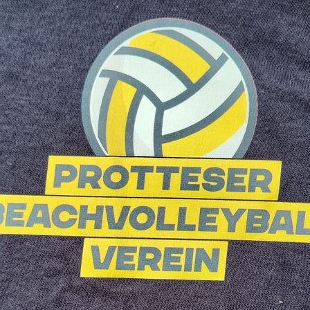 Ein grauer Stoff zeigt ein gelbes und weißes Volleyball-Logo, mit Text darunter, der in fetten gelben Buchstaben 'PROTESTER BEACHVOLLEYBALL VEREIN' lautet.