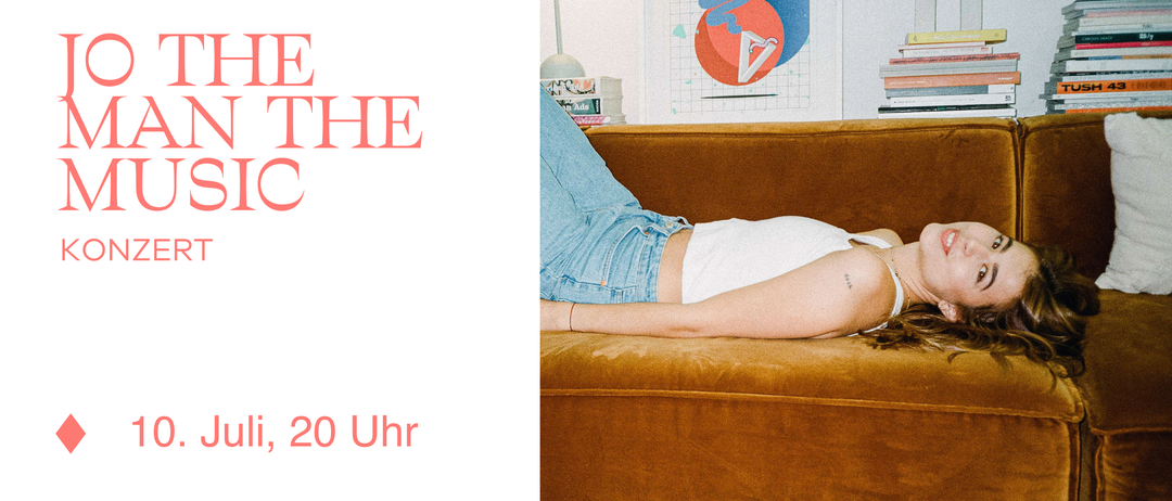 Eine Person liegt mit einem Kissen auf einer Couch, trägt Jeans und einen Armreif, mit einem roten Dreieck im Hintergrund.
