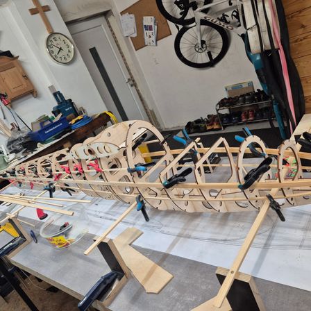 Bild enthält, Plywood, Wood, Machine, Wheel, Building, Factory, Manufacturing, Watercraft, Bicycle, Workshop