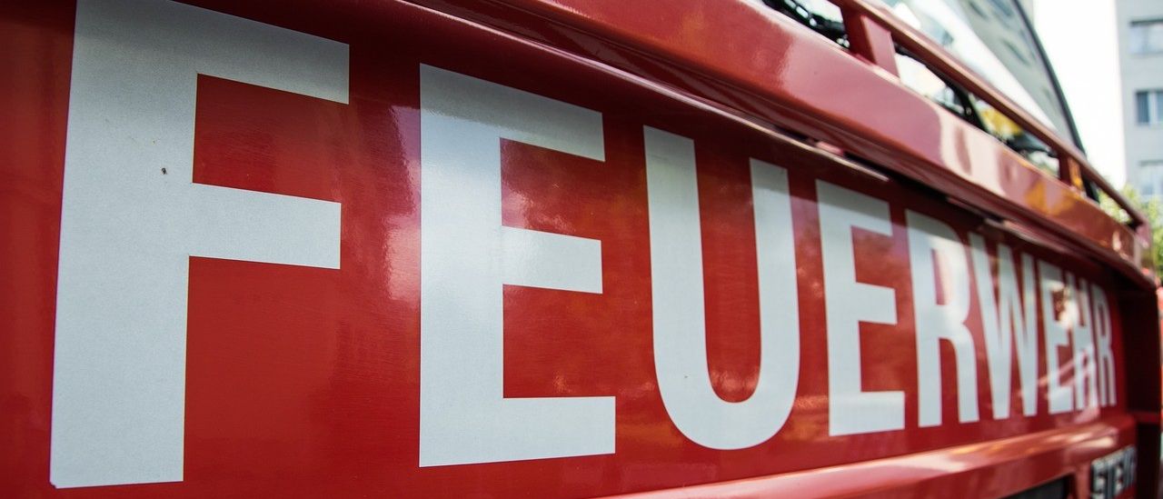 Eine Nahaufnahme eines roten Fahrzeugs mit weißen Buchstaben, die 'FEUER' bilden, wahrscheinlich ein Feuerwehrauto.