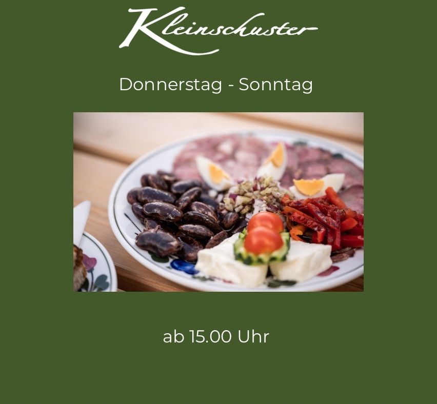 Ein Teller mit Fleisch, Eiern, Bohnen, Käse und Gemüse auf einem Holztisch. Der Text lautet 'ab 15.00 Uhr'. Der Hintergrund hat das Logo 'Kleinschuster' mit dem Text 'Donnerstag - Sonntag'.