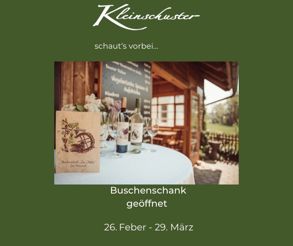 Eine Außenszene mit einem Tisch, der mit einem weißen Tuch bedeckt ist. Weinflaschen und Gläser sind auf dem Tisch arrangiert. Ein Menübrett ist an der Wand dahinter. Der Text auf dem Poster lautet 'Buschenschank geoffnet'.