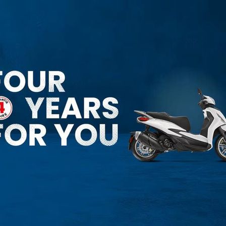 Ein weißer Roller mit blauem Hintergrund zeigt den Text 'Vier Jahre für Sie' und ein Logo mit der Nummer 4.