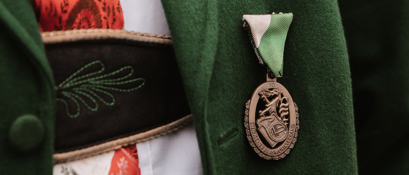 Bild enthält, Coat, Formal Wear, Logo, Dress, Jacket, Badge, Symbol, Gown, Overcoat, Locket