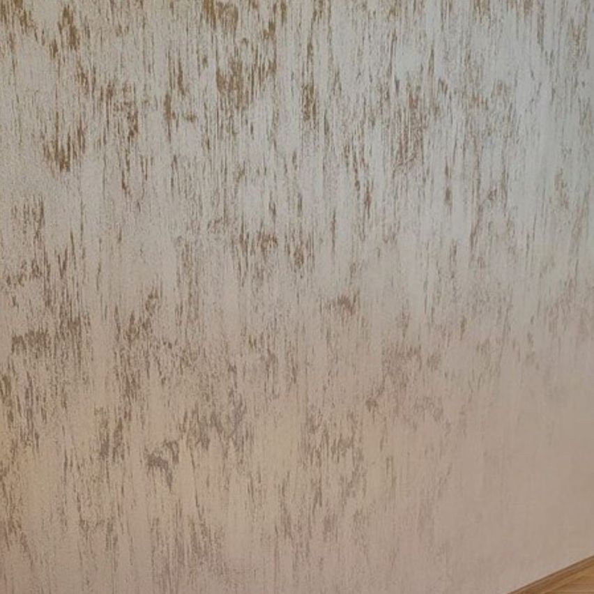 Eine dekorative Innenwand mit hochwertiger Spachteltechnik und strukturierter Oberfläche in einem modernen Wohnraum.