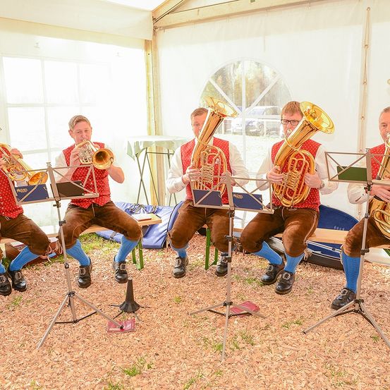 Bild enthält, Group Performance, Person, Brass Section, Horn, Musical Instrument, Tuba, Music Band, Shoe, Glasses, Wristwatch