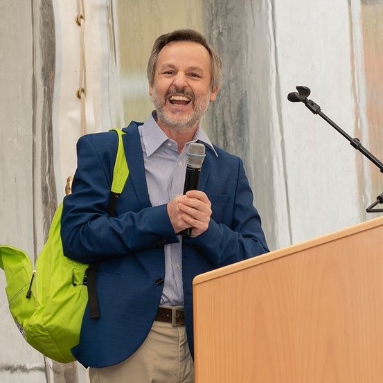 Bild enthält, Crowd, Person, Adult, Male, Man, Audience, Microphone, Podium, Speech, Suit