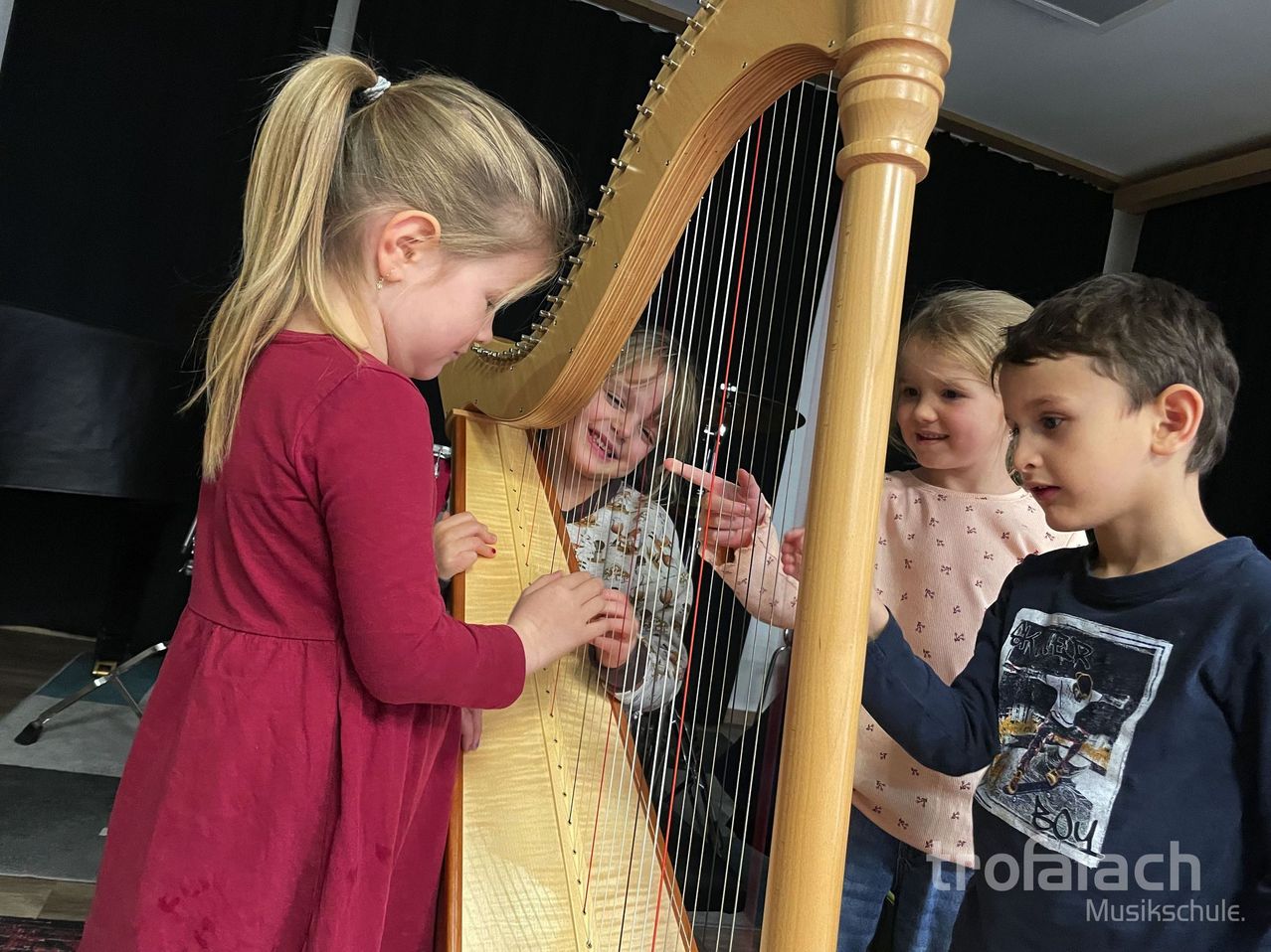 Bild enthält, Child, Female, Girl, Person, Boy, Male, Musical Instrument, Face, Harp, Jeans