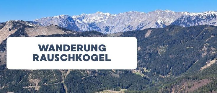 Eine Bergkette mit schneebedeckten Gipfeln und dichten Wäldern, beschriftet mit 'Wanderung Rauschkogel'. Der Himmel ist klar und blau.