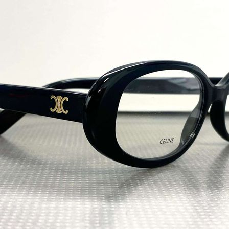 Ein Paar schwarze Brille mit einem goldenen Logo an der Seite und dem Markennamen 'CELINE' auf der Linse geschrieben.