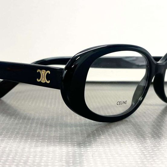 Ein Paar schwarze Brille mit einem goldenen Logo an der Seite und dem Markennamen 'CELINE' auf der Linse geschrieben.
