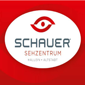 Schauer Sehzentrum Logo in Rot und Weiß, mit einem Augensymbol und dem Namen Schauer, gelegen in Hallein Altstadt. Unten auf dem Logo werden das Institut für Präzisions-Kontaktlinsen, Optometrie, Designerbrillen und spezielle Sehhilfen erwähnt.