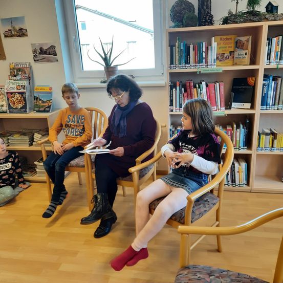 Bild enthält, Furniture, Book, Library, Person, Sock, Bookcase, Head, Conversation, Sitting, Student