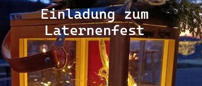 Eine Laterne mit einem Weihnachtsbaum im Inneren, geschmückt mit Tannenzapfen, roten Beeren und Lichterketten. Die Laterne hat einen braunen Lederriemen und steht vor einem Hintergrund aus immergrünen Pflanzen.